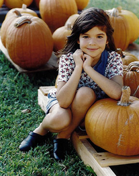 Photograph of girl with pumpkins